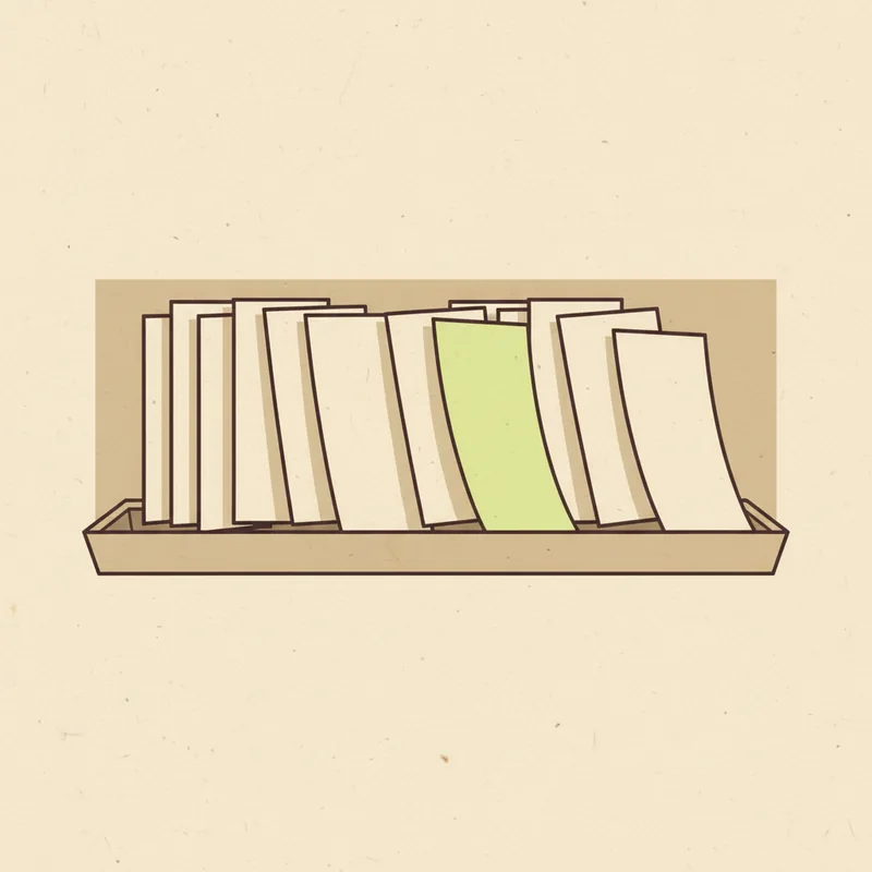 A long row of upright blank paper sheets packed into a shallow tray, each leaning at a slightly different angle, with one sheet near the middle picked out in pale green